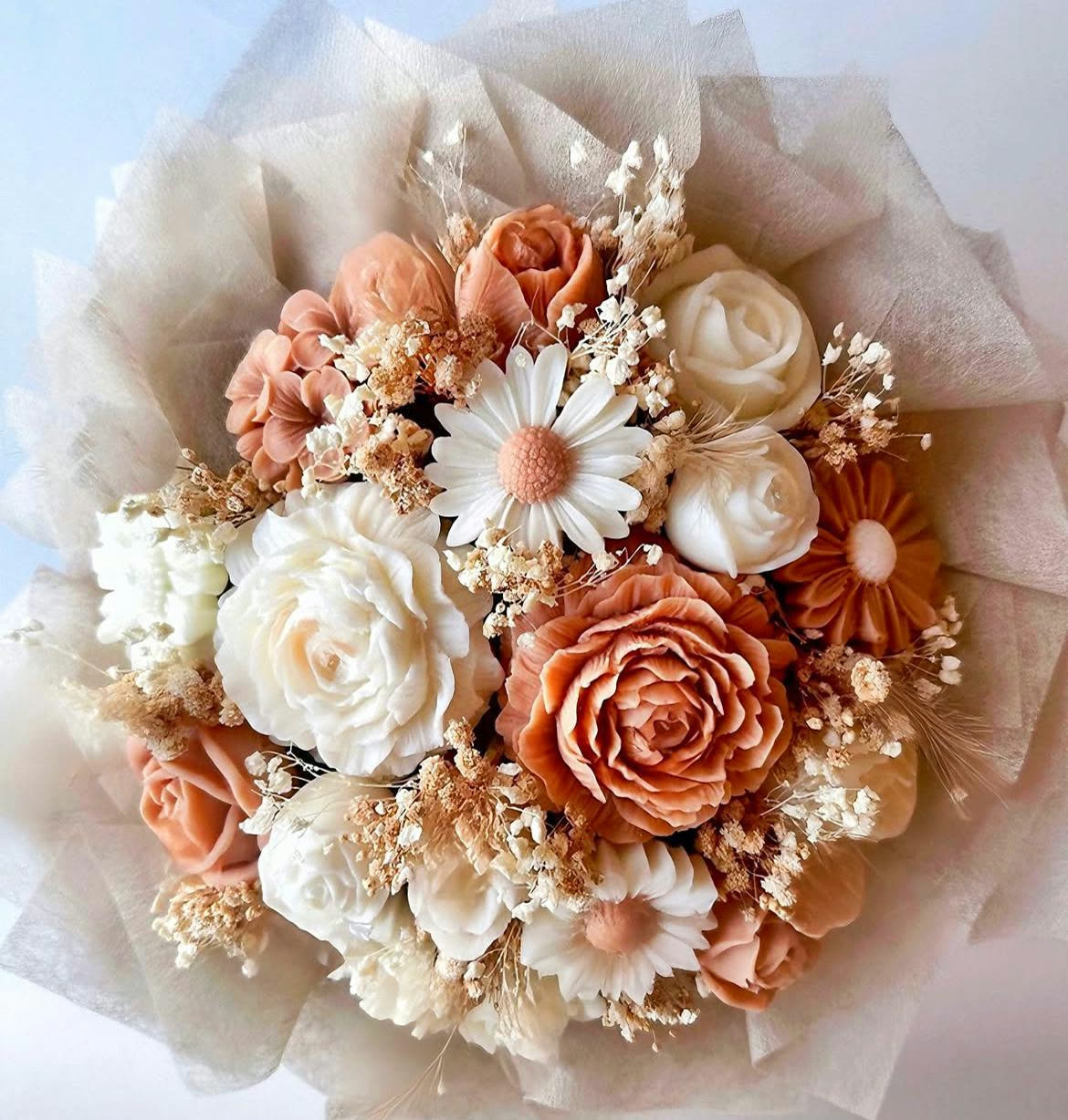 Bouquet di candele a fiore in cera nei toni pesca e avorio, avvolto in tulle