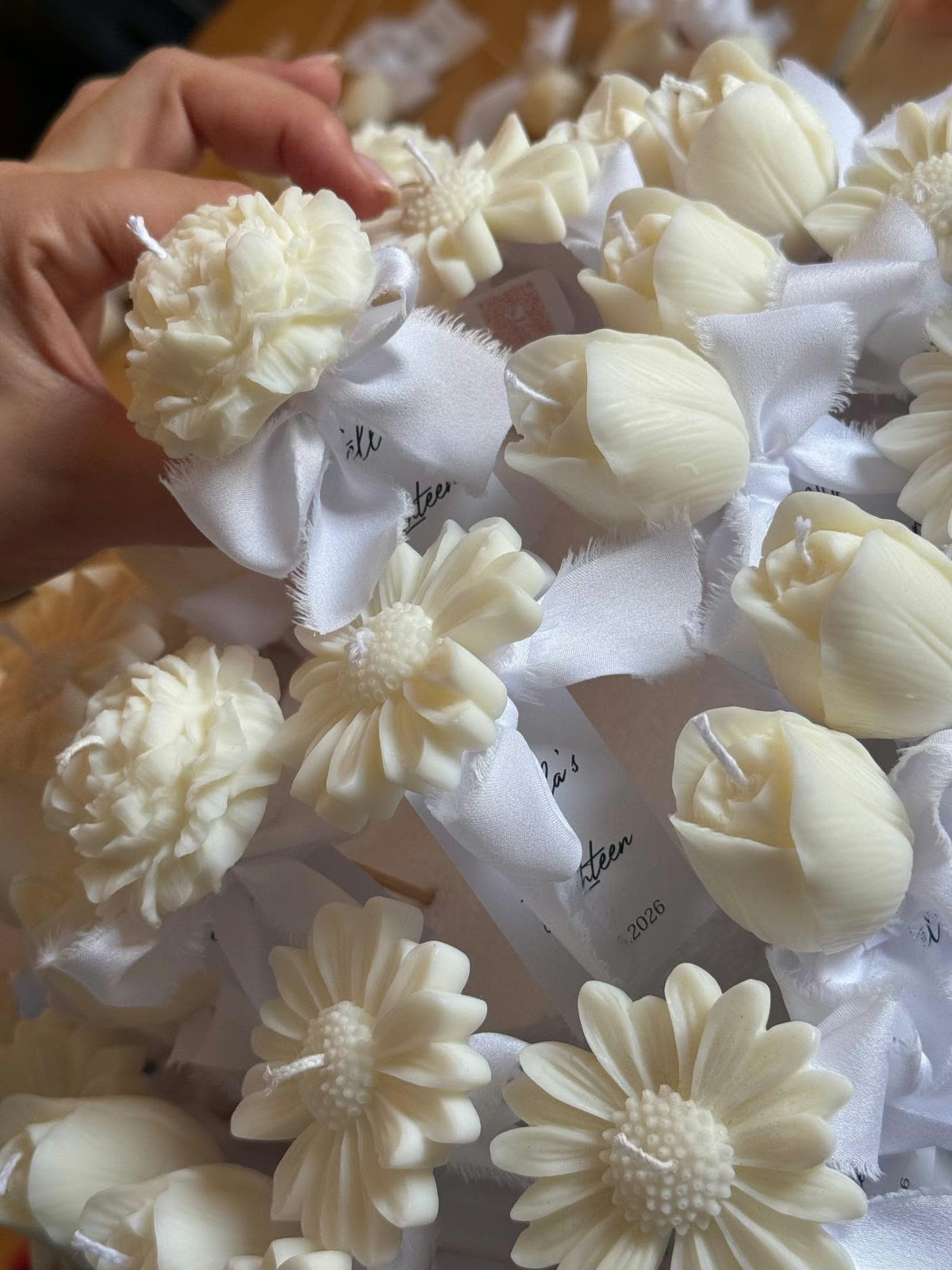 Candele a fiore in cera d’avorio con nastri in seta bianca e tag personalizzati