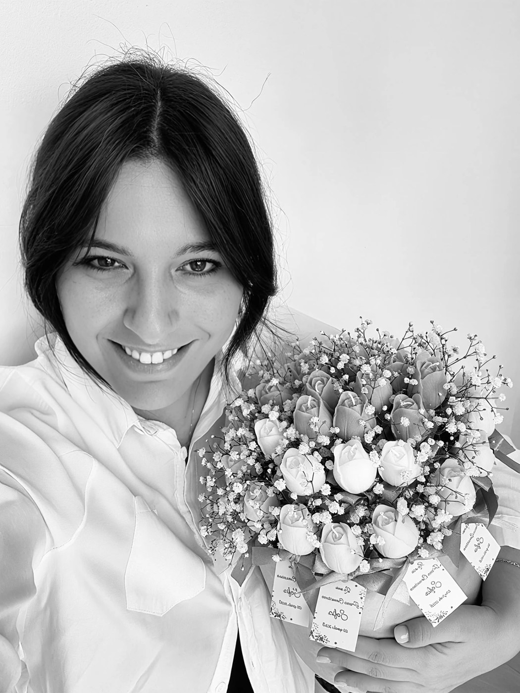 Giorgia, fondatrice di Nina Candles, con un bouquet di candele a forma di tulipano e rosa