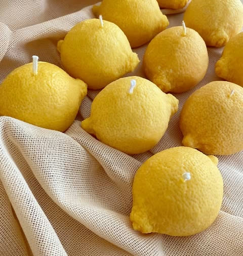Candele scultoree a forma di limone in cera di soia gialla su tessuto in lino naturale